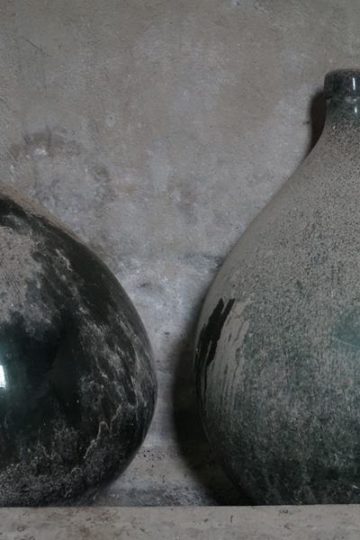 2 bolle groene flessen met stof erop