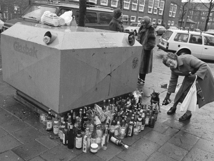 oude zwart witte foto van mensen bij de glasbak