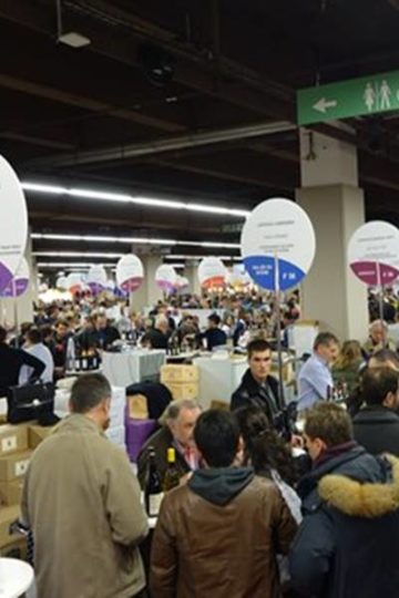 beurs van de vigneron independant in parijs, standjes met een rond bord met de naam en soort wijn en heel veel mensen