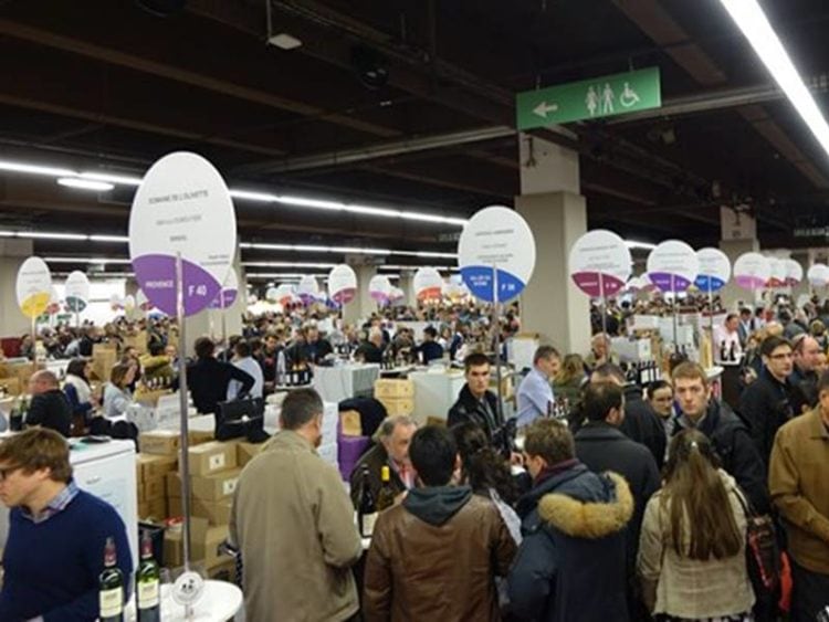 beurs van de vigneron independant in parijs, standjes met een rond bord met de naam en soort wijn en heel veel mensen