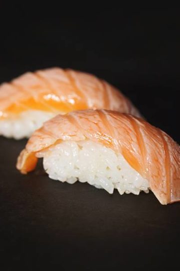 sushirijst met zalm tegen een zwarte achtergrond