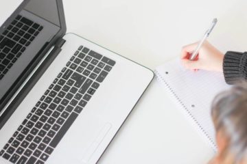 open laptop met notitieblok en pen om cursus te maken