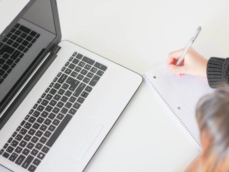 open laptop met notitieblok en pen om cursus te maken