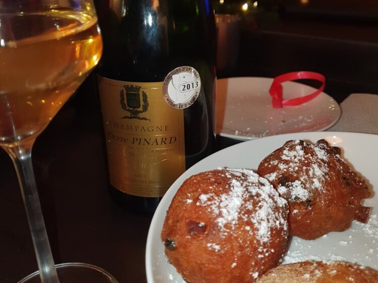oliebollen met een fles champagne op de achtergrond
